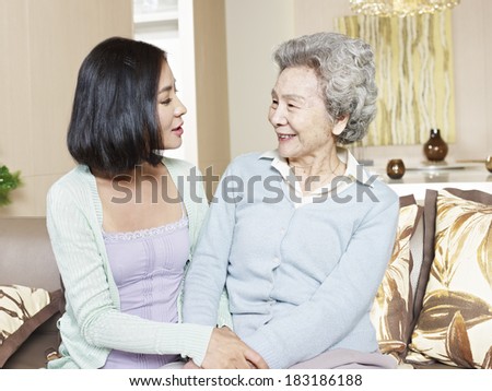 senior asian mother chatting with adult daughter at home