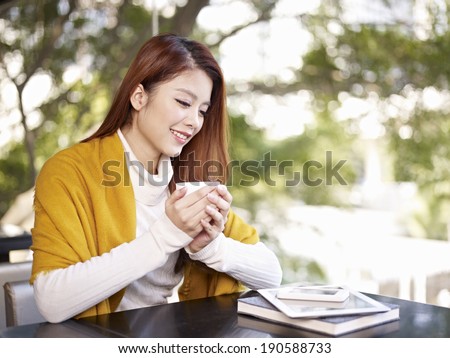 young woman holding coffee cup smiling.