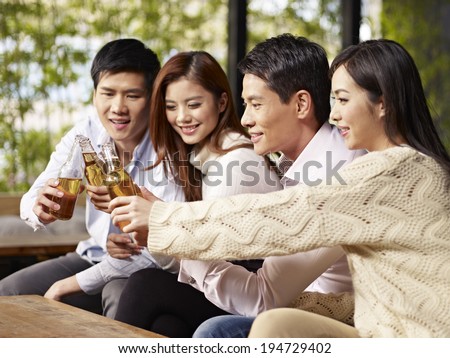 young asian friends gathering chatting drinking beer.