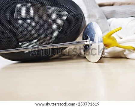 fencing mask and rapier on floor.