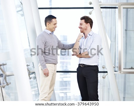 caucasian business executive praising subordinate by giving a pat on the shoulder.