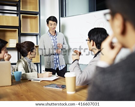 young asian businessman facilitating a group discussion or training in office.
