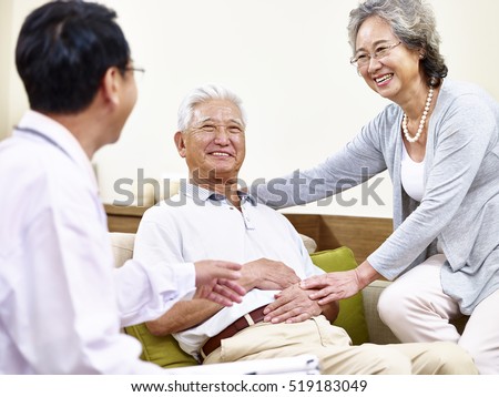 senior asian patient being taken care of by his wife and a family doctor
