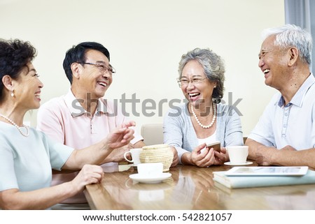 small group of senior asian people getting together talking and laughing