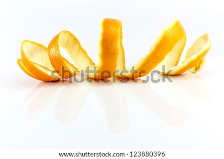 Spiral orange peel reflecting on white background.