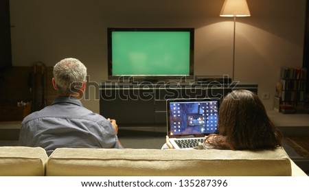 Mid Adults watching TV and PC thanks to Internet possibilities