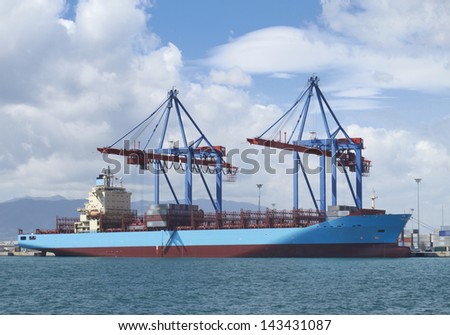 Cargo Container terminal with gantry cranes at Malaga sea port in the moment of shipment