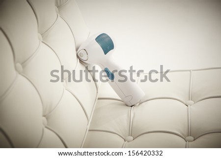 Electronic machine for corporal massage on armchair against white background