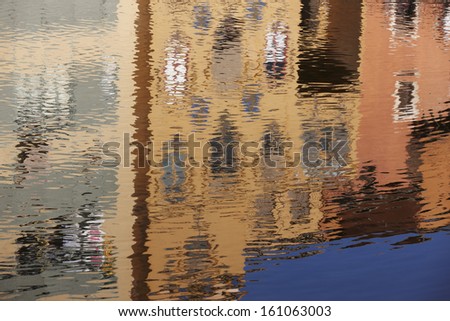Water reflections of colorful houses on the sea surface