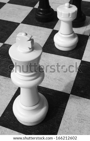 White chess king figure against black and white squares