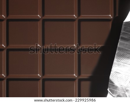 Dark chocolate bar with aluminum foil. Horizontal format