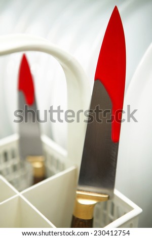 Knives with fresh blood in a dishwasher. Vertical format