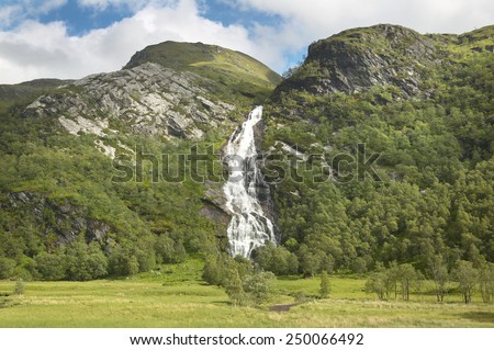 Scottish landscape with forest, mountain and waterfall. Horizontal