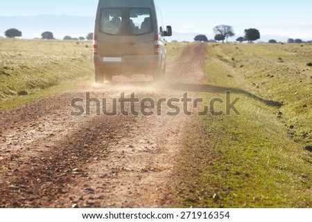 Dirty road in a mediterranean meadow with minibus. Cabaneros. Spain. Horizontal