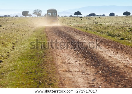 Dirty road in a mediterranean meadow with minibus. Cabaneros. Spain. Horizontal
