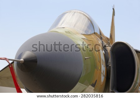 Fighter aircraft nose and cabin detail with blue sky background. Horizontal