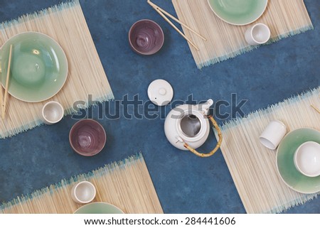Japanese tea table with cups and dishes viewed from above. Horizontal