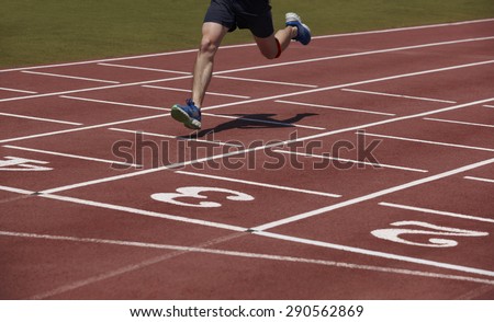 Detail of a male athlete crossing the finish line. Horizontal