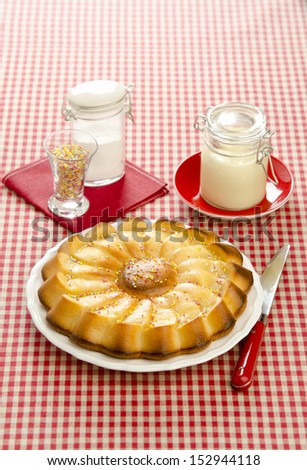 Cake with condensed milk on a white plate and checkered tablecloth