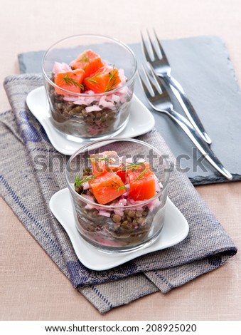 lentil salad with salmon in glass cups on a napkin
