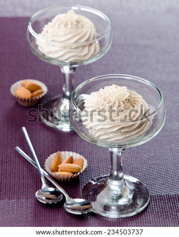 almond cream in glass goblets on a lilac background