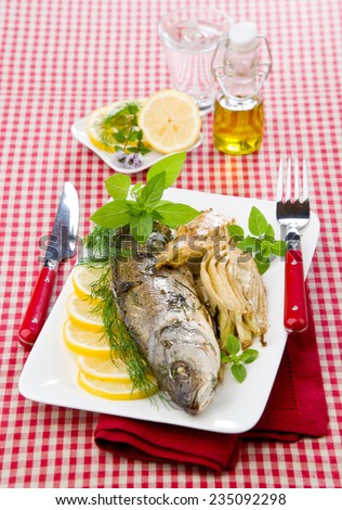 Baked sea bass with fennel lemon dill on white dish cloths to cell