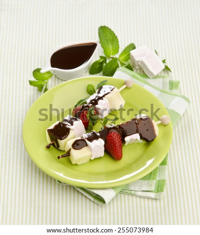Sweet Fruit Skewers with marshmallow drizzled chocolate sauce with mint