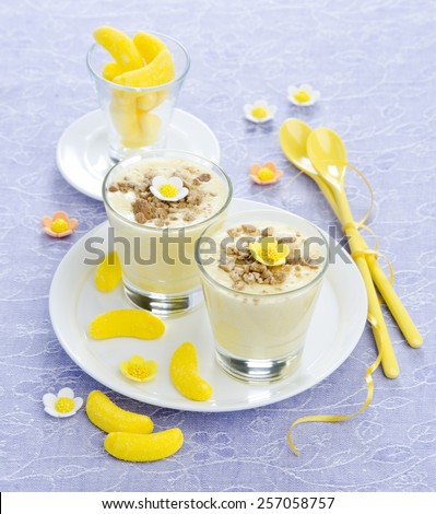 mascarpone mousse with banana candy in glass cups adorned with sweet flowers
