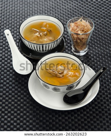 crab soup in ceramic bowls ceramic spoons in oriental style on a black background
