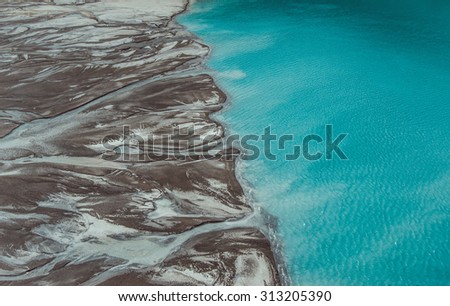 River delta flowing into the blue pond. Top view. Aerial photography.