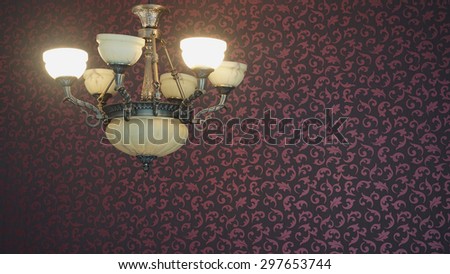 a classic pendant lamp on living room with red wallpaper