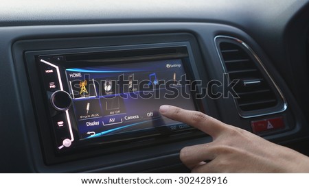 a women turn off her audio system in her car