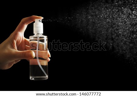 Female hand holding cosmetic spray bottle