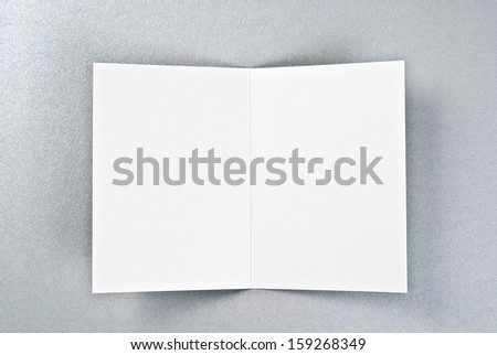 White card or sheet of paper over silver background