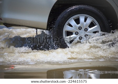 Splash by a car as it goes through flood water