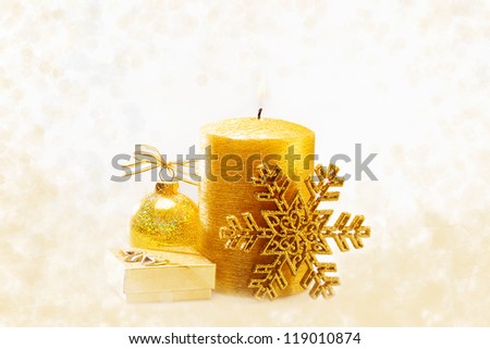 Winter holiday background with golden present gift box, candle ornament & Christmas snow decoration
