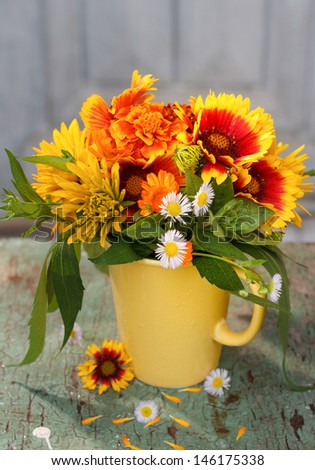 Bouquet of summer flowers in a yellow mug