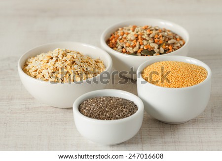 Raw organic amaranth ,chia seeds,oats and other healthy grains in small bowls