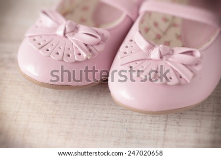 Detail of a pink girl shoes over wooden deck floor. Filtered image.