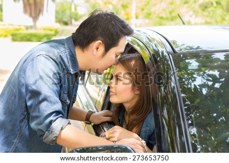 Young couple kissing on the car