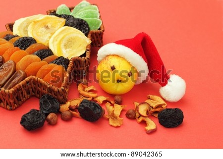 Apple in Santa Claus hat surrounded with dried fruit