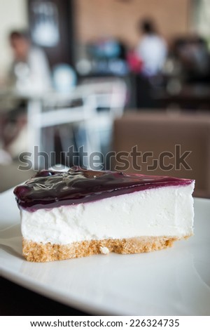 blueberry cheesecake (selective focus) in the white plate on the dark wooden table.