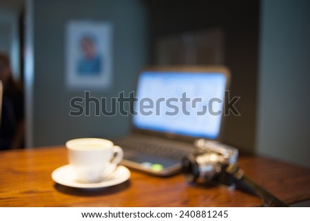Blur coffee cup with laptop and vintage camera for working in coffee shop scene - vintage instagram effect filter