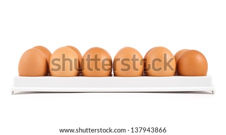 Dozen, twelve eggs in a special plastic case isolated over white background, side view