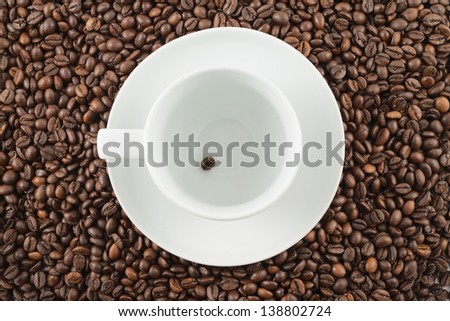 Single coffee bean inside a white ceramic cup