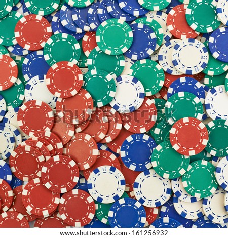 Surface covered with casino playing chips as a gambling background composition
