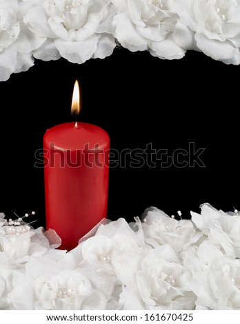 Mourning candle and white roses composition over black background