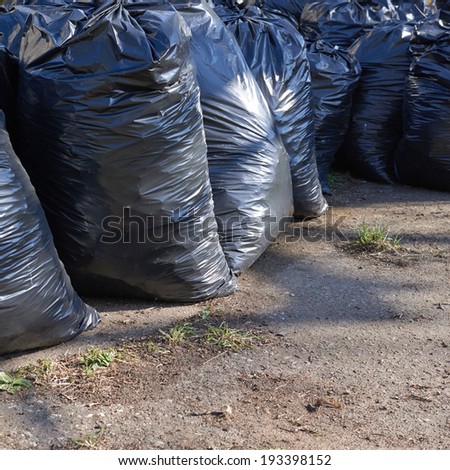 Pile of black plastic garbage bags on the ground