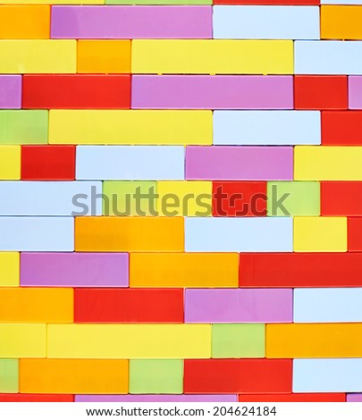 Fragment of the wall made of colorful plastic toy construction bricks as a background texture composition