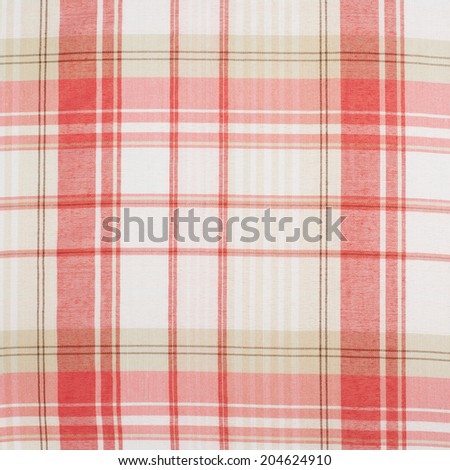 Fragment of a red and white squared cloth fabric as a background texture